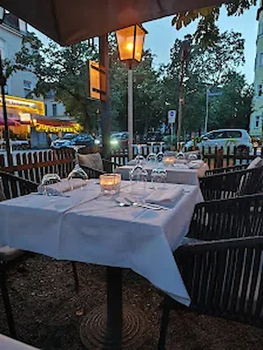 Terrasse zur blauen Stunde mit gedeckten Tischen und Kerzenlicht — Ristorante Risotto München